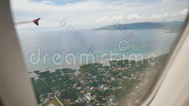 从一架飞行飞机的窗户俯瞰菲律宾岛屿。 在热带上空飞行时射击